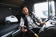 © Serhii - Truck driver cleaning interior of semi truck cab