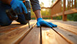 © Viktor - Worker installing wooden deck floor. Man in gloves fastens boards with drill. Home improvement project. Bricolage work. Construction worker repairs terrace. Renovation of house backyard with power
