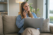 © Miljan Živković - Woman smiling talking on smart phone working from home