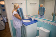 © Eva Corbella - Woman drying her face with a towel in a bright bathroom during morning routine