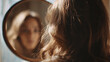 © jiratip - A woman contemplating her reflection in a mirror