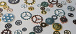© Nadzeya - Clockwork spare parts different colored gears on table concept