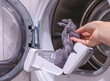 © Nataliia - close up female hand taking lint out from dirty air filter of dryer machine after drying. cleaning Dirty filter. hair, wool from the filter in hand. Front Load Tumble Laundry electric Dryer Machine.