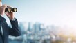 © backup_studio - Man looking through binoculars into the distance over a blurred city panorama. Searching for future business opportunities and vision.