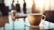 © backup_studio - Cup of latte coffee on glass table with blurred business people in background. Corporate break time concept.
