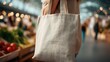 © backup_studio - Woman carrying a reusable canvas tote bag for grocery shopping. Sustainable living and zero waste concept with eco friendly product.