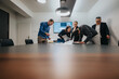 © qunica.com - A group of professionals in a conference room working together on a project with dedication.