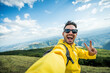 © Davide Angelini - Young hiker man taking selfie portrait on the top of mountain - Happy guy smiling at camera - Hiking, sport, travel and technology concept - Bright filter