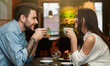 © Prostock-studio - Young Lovers Enjoying Coffee Drinks Together During Romantic Date In Cafe. Love And Dating. Side View