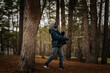 © Emvats - A boy in a gray hoodie and blue puffer jacket throws a disc on a grassy field with a forest backdrop. Dynamic action shot during cool weather.