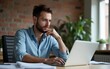 © Matthew - Portrait of attractive young businessman using laptop computer at office desk. paperwork and other items. caucasian european bearded guy in casual wear outfit is concentrated on work thinking