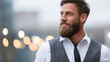 © GrayFrog - Well-dressed man with beard and tie, exuding a confident and stylish look against a soft, blurred background of lights.