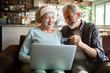 © Geber86 - Senior husband and wife smiling while shopping online at home