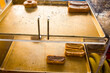 © Mint Images - Donuts and cakes with chocolate icing on a tray in a shop window, a few left.