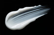 © MDSHAHINUL - A thick white cosmetic cream swatch on a black background