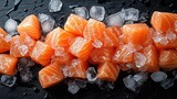A close-up of raw salmon pieces and ice cubes on a black surface. top view, background.