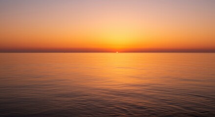  Brilliant golden sunlight touches the calm horizon above expansive tranquil water