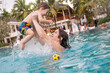 © Михаил Решетников - Caucasian woman holds her son while swimming in a pool on vacation. Mom teaches little boy to swim.
