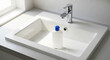© MrLynx - Antiseptic bottle standing in a white bathroom sink with silver faucet