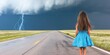 © imagineRbc - A young girl is walking down a road in front of a storm. The storm is in the background and the girl is wearing a blue dress