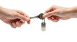 © Shahadat - Hands exchanging a key with a blank tag against a black background in a close up studio shot