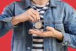 © Pixel-Shot - Young man with stopwatch on red background, closeup