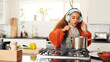 © FlexOn/peopleimages.com - Cooking, music and pot with woman in kitchen of home for flavor, food or meal preparation. Cuisine, headphones and streaming with person stirring at counter in apartment for diet, health or nutrition