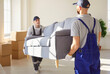 © Studio Romantic - Two men movers carrying sofa from apartment, helping people to move to other place of living. Hard working workers from delivery service helping clients with relocation. Furniture delivery