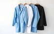 © Emily - Lab coats in various colors hanging on minimalist white background create clean and organized look. arrangement showcases blue, white, and black coats, emphasizing simplicity and professionalism