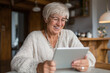© sashka1313 - A cheerful senior woman smiles while having an online video consultation with her doctor, showing a warm and reassuring telehealth moment.