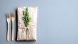© rocha - A simple, rustic gift presentation featuring two wooden forks and a rosemary sprig on a plain grey surface, suggesting a natural or eco-friendly theme.