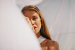 © Jacob Lund - Young woman posing gracefully under soft flowing fabric outdoors in warm sunlight