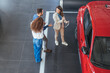 © Dragana Gordic - Business Meeting In Car Showroom With Red Car And Sales Team Discussing Tablet