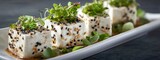 Elegant Platter of Sesame Seed Cubes with Fresh Greens Garnish for Culinary Presentation