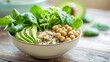 © Formoney - A vibrant bowl filled with leafy greens, sliced avocado, quinoa, and chickpeas is placed on a wooden table. The bright kitchen setting adds a fresh feel, showcasing healthy eating.