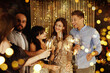 © New Africa - Happy New Year 2026 greeting card, bokeh lights. Friends celebrating with sparklers and wine glasses indoors