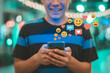 © Pixel Studio - Smiling man interacts with social media on his smartphone receiving likes comments and emoji reactions showcasing digital engagement and online communication in a modern connected world