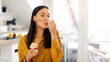 © Home-stock - Happy young woman enjoy eating tasty ice cream with closed eyes, sitting in kitchen interior at home, free space