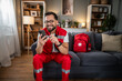 © Migma_Agency - Paramedic man relaxing at home while texting on phone
