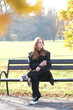 © Yevhen - Girl is sitting on a bench in city autumn park with paper cup of coffee