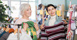 © JackF - Fashionista Armenian woman and mature female colleague near showcase examine goods, are busy choosing knitted winter sweater. Client enjoy shopping