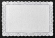 © MakeStories.com - White lace edge rectangular paper doily on dark grey background