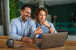 © Miljan Živković - Couple having a happy video call on laptop at home