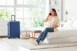 © Pixel-Shot - Female tourist talking by mobile phone on bed in hotel room