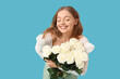 © Pixel-Shot - Beautiful happy young woman with bouquet of white roses on blue background