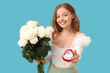 © Pixel-Shot - Happy young woman with engagement ring and bouquet of white roses on blue background