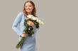 © Pixel-Shot - Beautiful happy young woman with bouquet of white roses on grey background