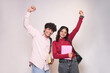 © GAJENDRRA BHATI  - Cheerful indian gen Z college students with backpack and books standing isolated on white background. Excited young asian adult high school boy and girl looking at camera having fun. Admission open.
