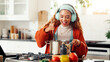 © FlexOn/peopleimages.com - Headphones, cooking or happy woman with pot in kitchen, culinary audio guide or meal preparation. Music tech, home or person with healthy eating podcast for nutrition inspiration, stir food or listen