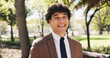 © AzeemudDeen25/peopleimages.com - Portrait, smile and travel with lawyer outdoor in city for route to work as legal council or representation. Commute, justice and opportunity with happy employee walking in park for job as attorney